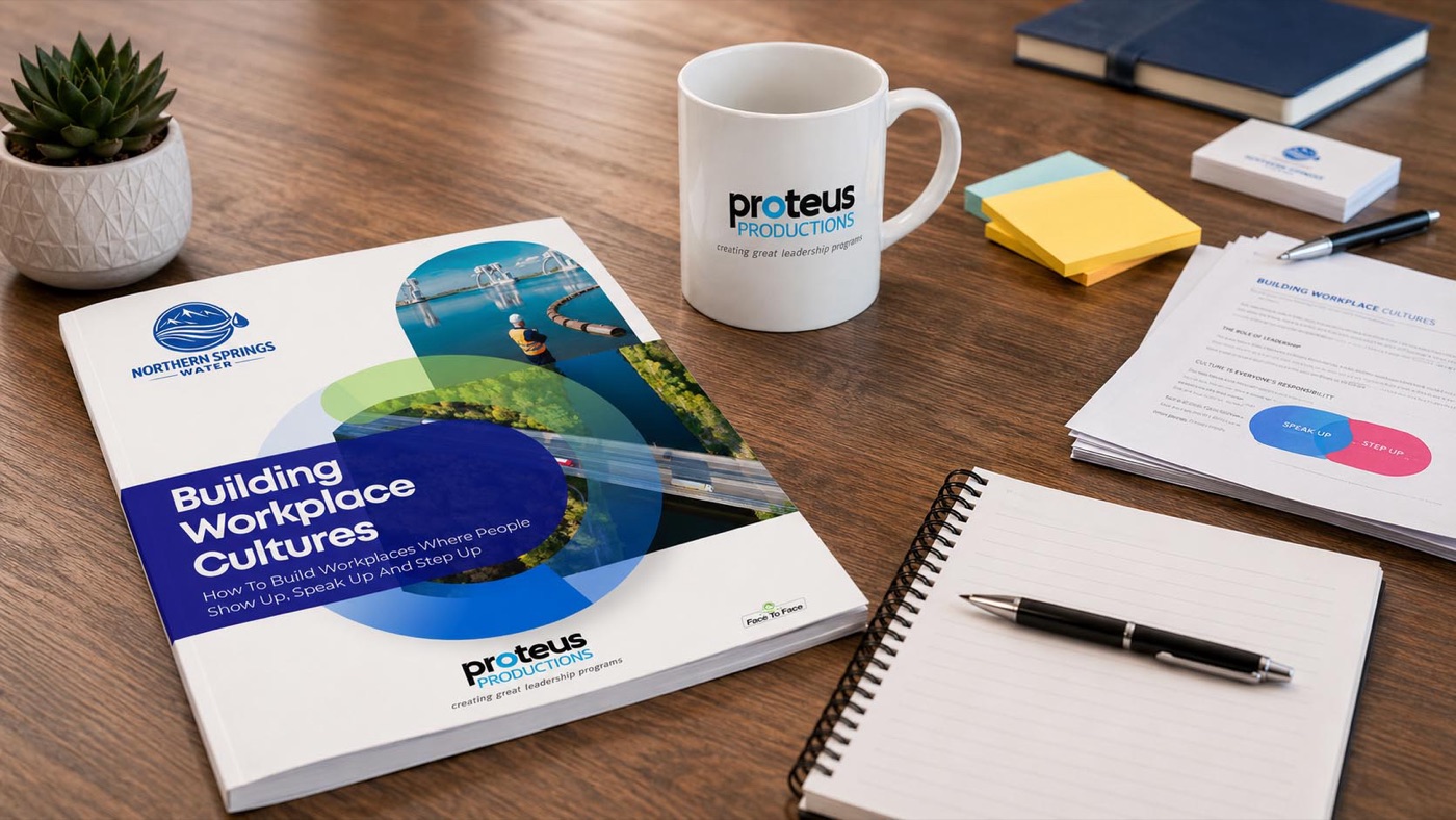 A printed Proteus Productions workbook and materials on a desk